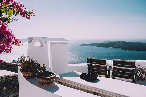 two brown wooden chairs beside the wall